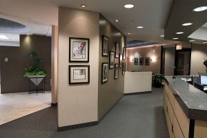 Moats Dental hallway and front desk with framed potraits displayed on the wall