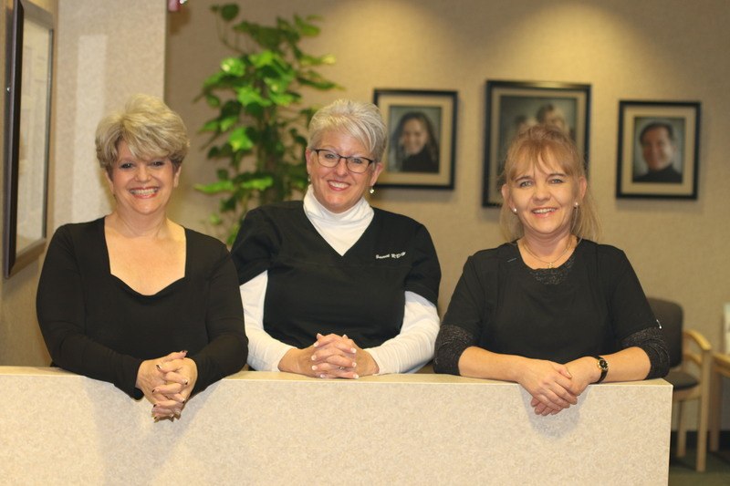 moats dental staff of 3, wearing black scrubs and smiling