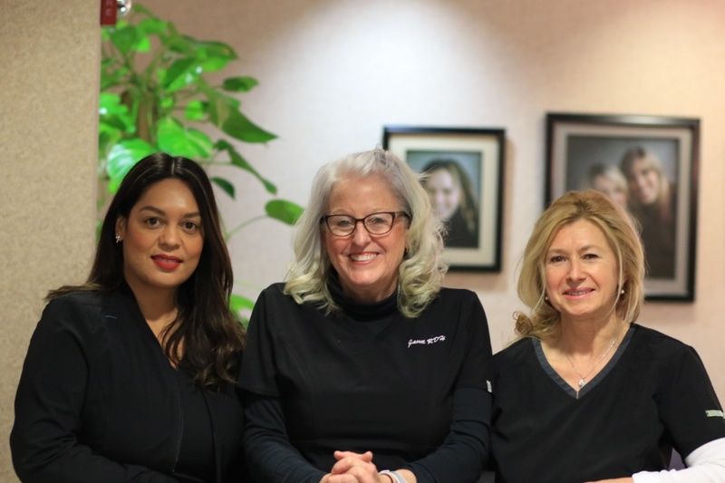 moats dental staff of 3, wearing black scrubs and smiling